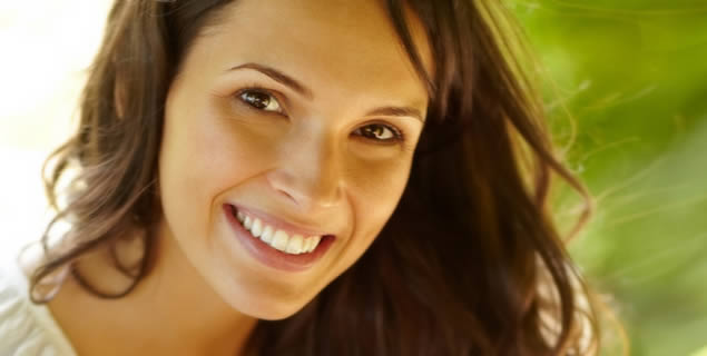 A woman smiling after getting same day dental crowns in Alexandria.