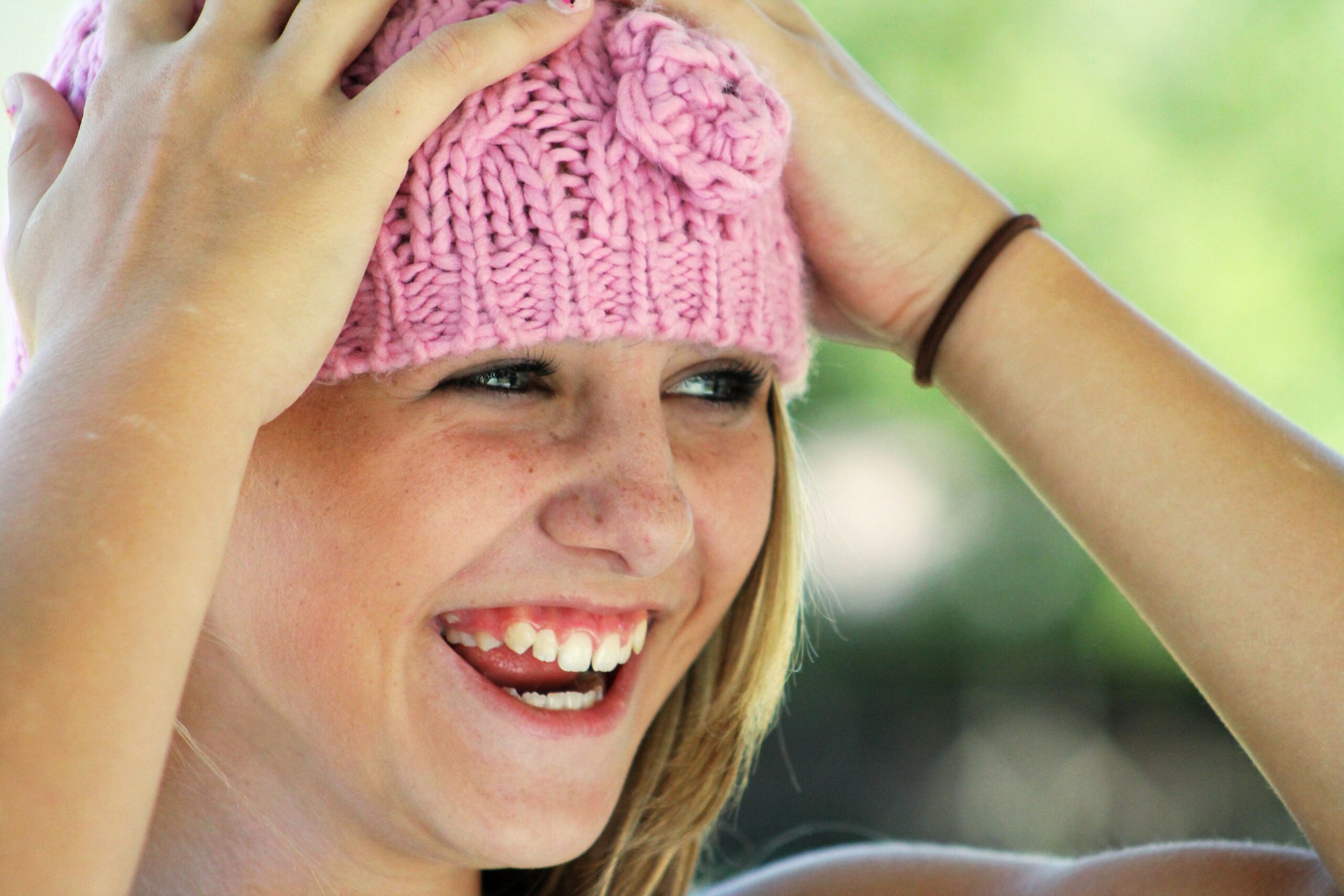 A young girl smiling in a pink hat after a back-to-school dental exam in Alexandria.