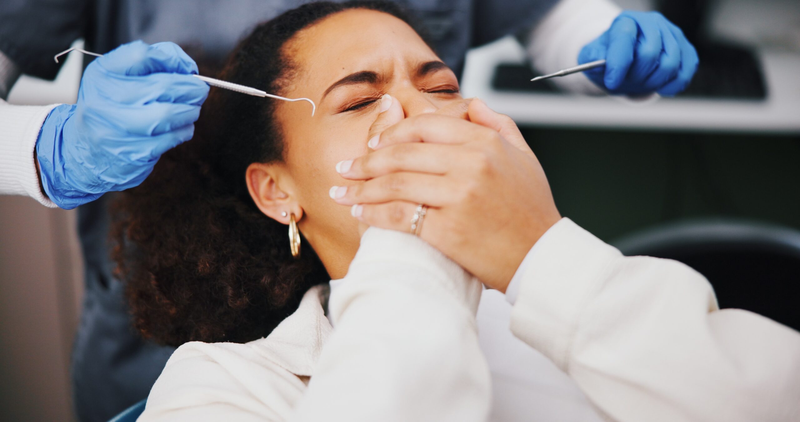 young woman covering her mouth, afraid of a root canal
