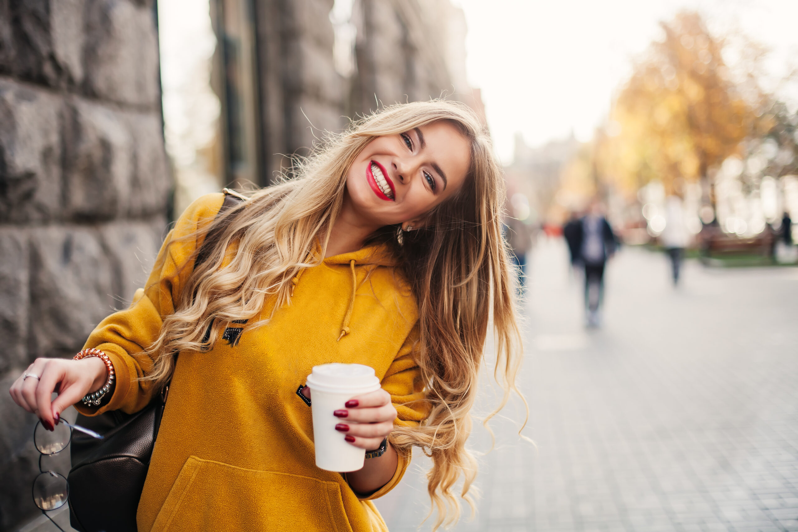 young woman in a yellow sweater smiling, showing off her cosmetic dental work in Alexandria